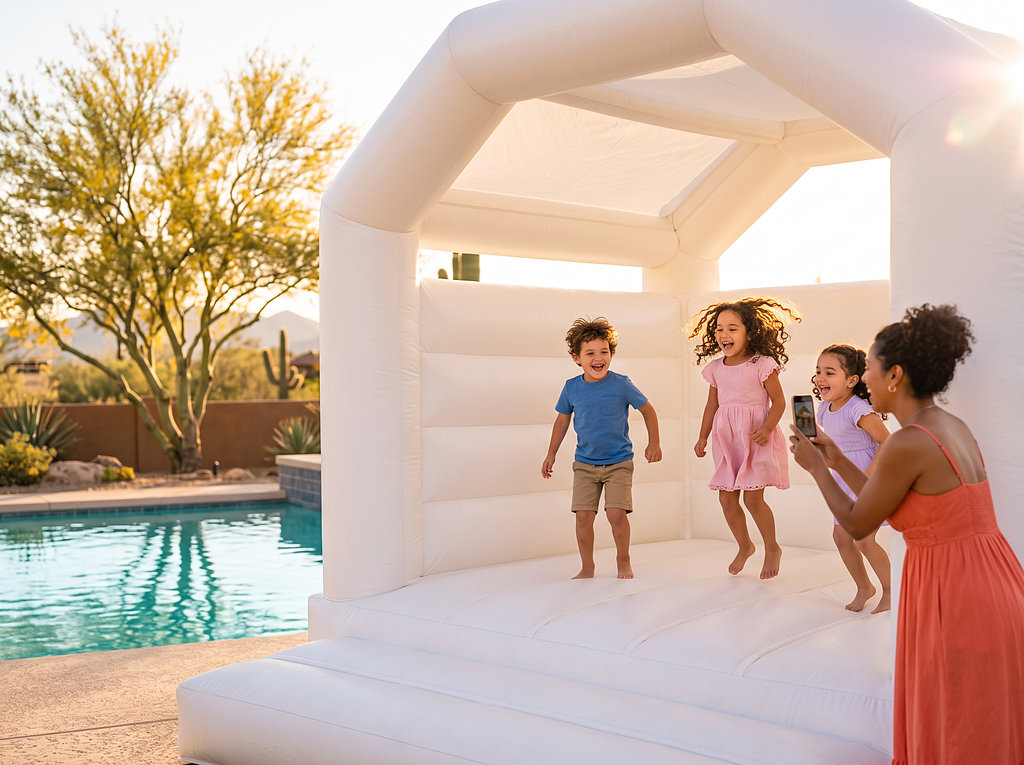 Kids jumping in the white jump house by the pool while mom films